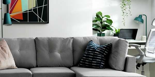 A grey Habitat right corner sofa with wooden legs placed in a white living room. 